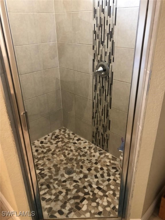 bathroom featuring a shower with door