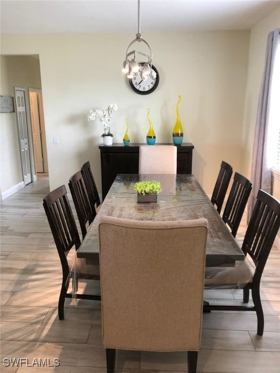 dining space featuring wood-type flooring and a chandelier