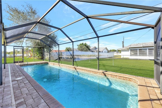 view of swimming pool with a patio, a yard, and glass enclosure