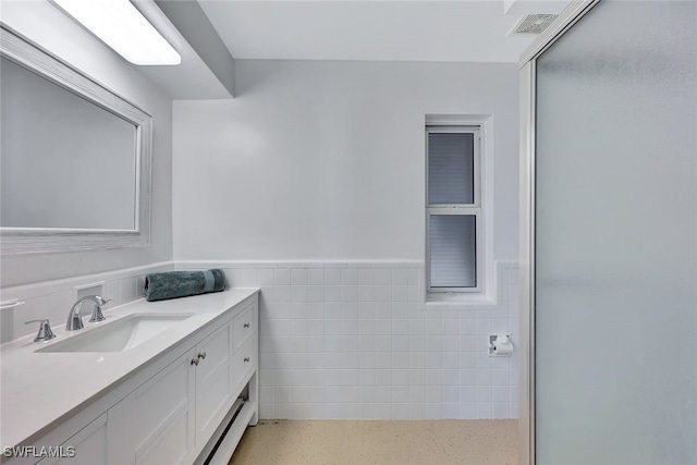 bathroom with vanity, tile walls, and walk in shower