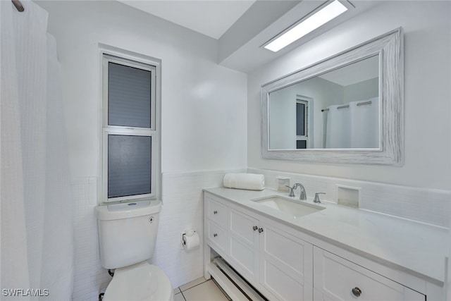 bathroom with tile patterned floors, vanity, toilet, and tile walls