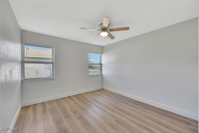 spare room with ceiling fan and light wood-type flooring