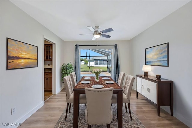 dining space with ceiling fan and light wood-type flooring