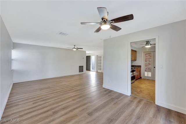 unfurnished living room with a fireplace, ceiling fan, and light hardwood / wood-style flooring