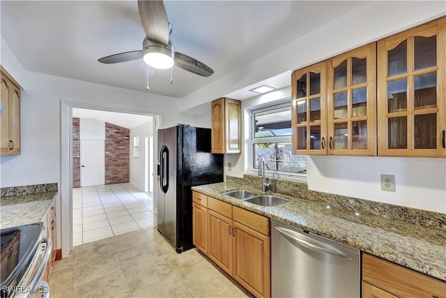 kitchen featuring appliances with stainless steel finishes, sink, light tile patterned floors, ceiling fan, and light stone countertops