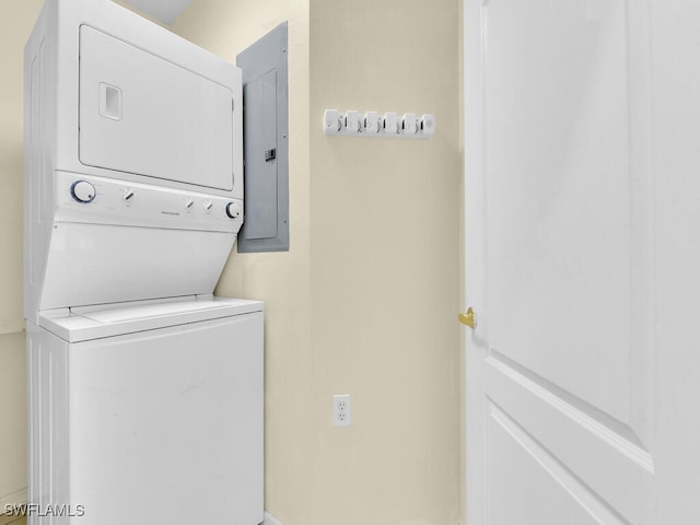 laundry room with electric panel and stacked washing maching and dryer