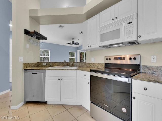 kitchen with sink, dark stone countertops, ceiling fan, stainless steel appliances, and white cabinets