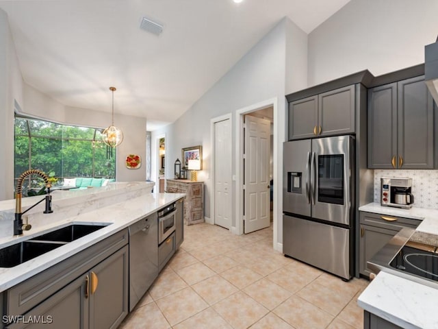 kitchen with pendant lighting, sink, dishwasher, stainless steel refrigerator with ice dispenser, and vaulted ceiling