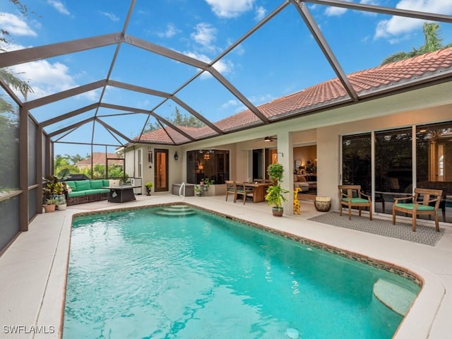 view of pool featuring ceiling fan, an outdoor living space, glass enclosure, and a patio