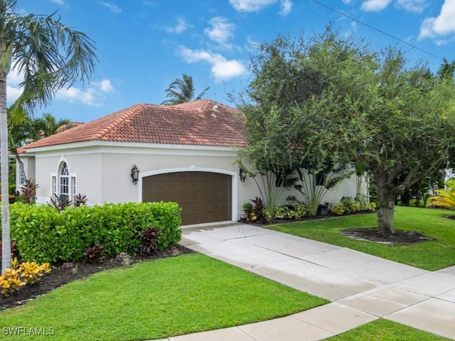 mediterranean / spanish-style home with a garage and a front lawn