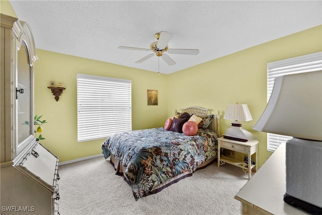 carpeted bedroom with ceiling fan and a textured ceiling