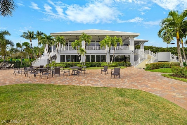 back of house featuring a patio area and a lawn