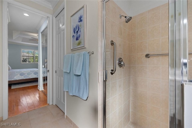 bathroom with tile patterned flooring, crown molding, an enclosed shower, and ceiling fan