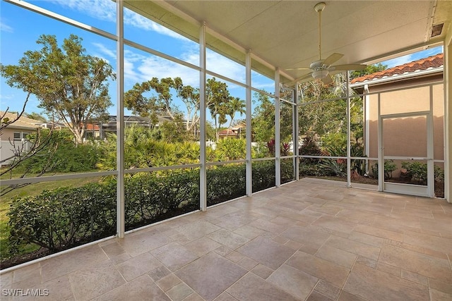 unfurnished sunroom with ceiling fan