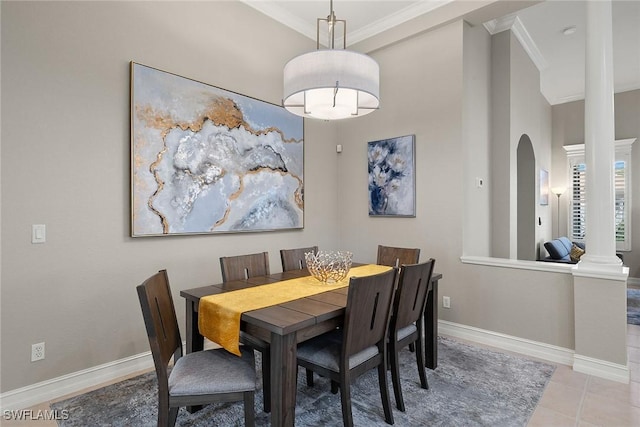 dining space featuring decorative columns, crown molding, and light tile patterned flooring