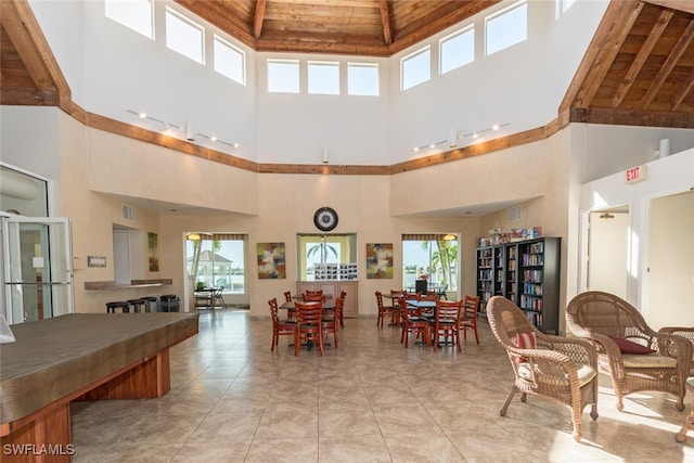 dining room featuring a towering ceiling and light tile patterned floors