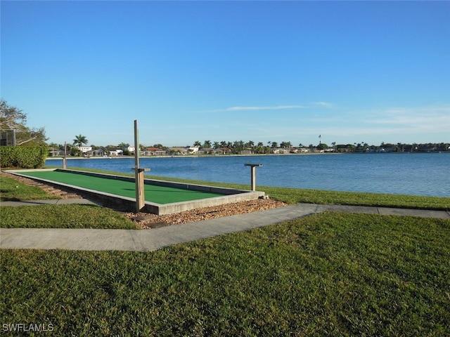 surrounding community featuring a water view and a lawn