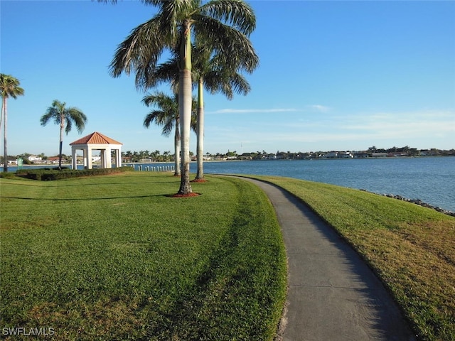 view of property's community with a gazebo, a water view, and a yard