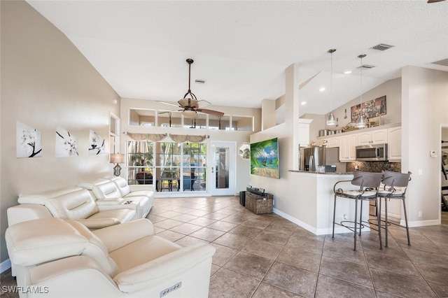 tiled living room with ceiling fan and lofted ceiling