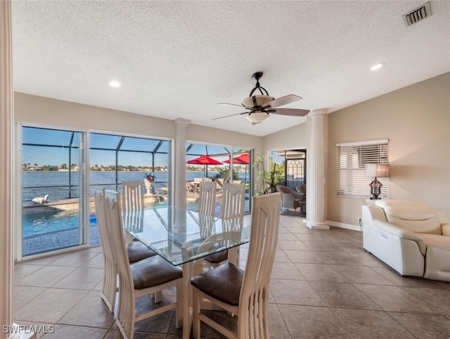 dining area with vaulted ceiling, a healthy amount of sunlight, and a water view