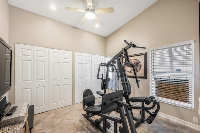 exercise area featuring light tile patterned flooring, vaulted ceiling, and ceiling fan