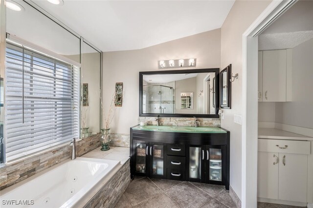 bathroom with vanity, lofted ceiling, shower with separate bathtub, and tile patterned floors