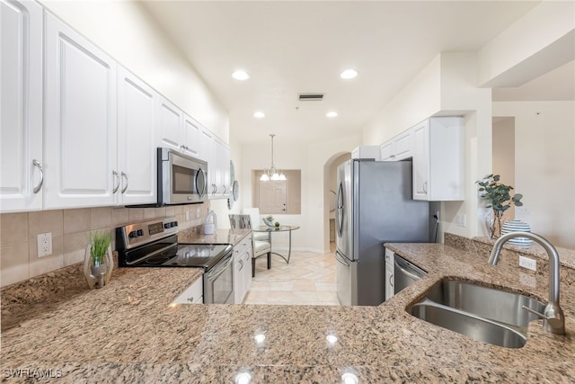 kitchen featuring sink, white cabinetry, backsplash, stainless steel appliances, and light stone counters