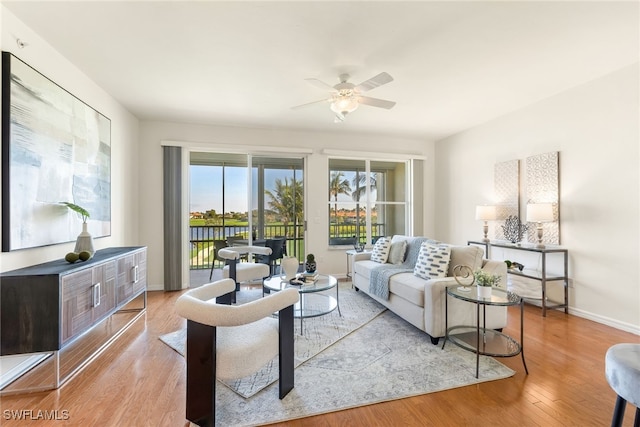 living room featuring ceiling fan and light hardwood / wood-style floors