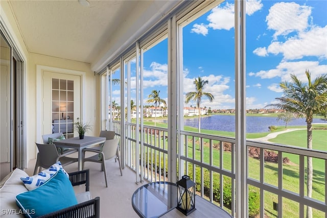 sunroom featuring a water view