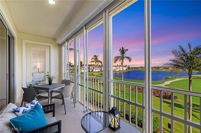 sunroom / solarium featuring a water view