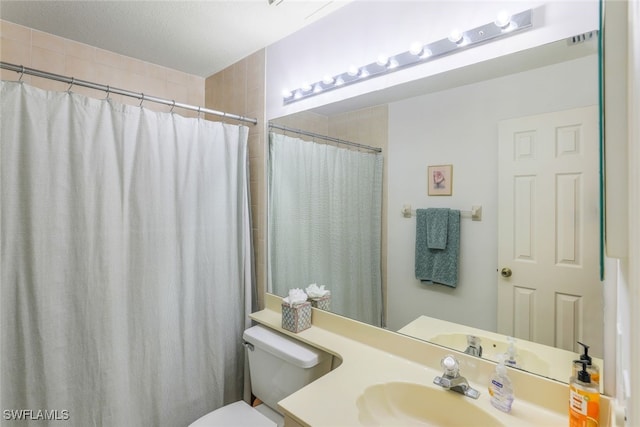 bathroom with vanity, curtained shower, and toilet