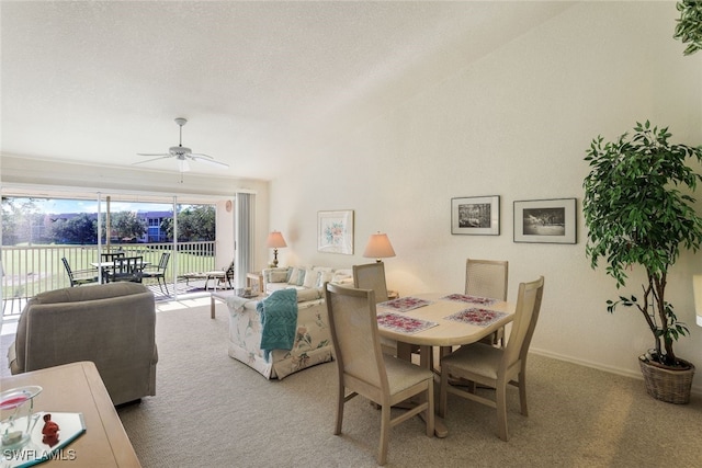 carpeted dining room featuring a textured ceiling and ceiling fan