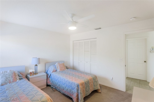 carpeted bedroom with ceiling fan and a closet