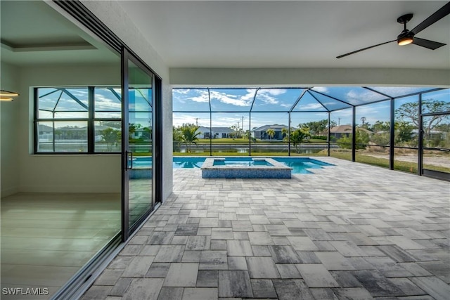 view of pool with an in ground hot tub, glass enclosure, and a patio