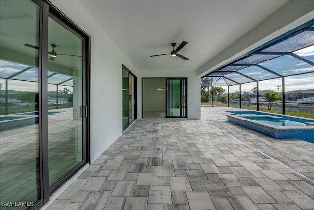 view of patio with an in ground hot tub and a lanai