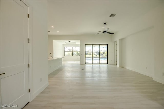 spare room featuring ceiling fan, sink, and light hardwood / wood-style floors