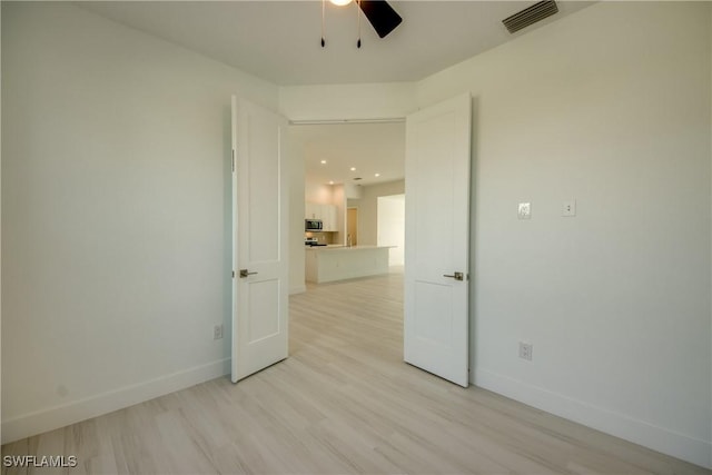 unfurnished room with ceiling fan and light wood-type flooring