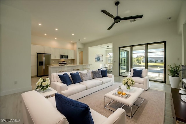 living room with ceiling fan and light hardwood / wood-style flooring