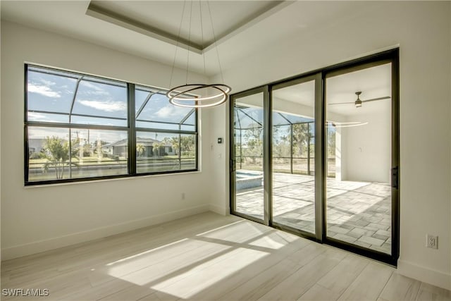 unfurnished room with hardwood / wood-style flooring and a raised ceiling