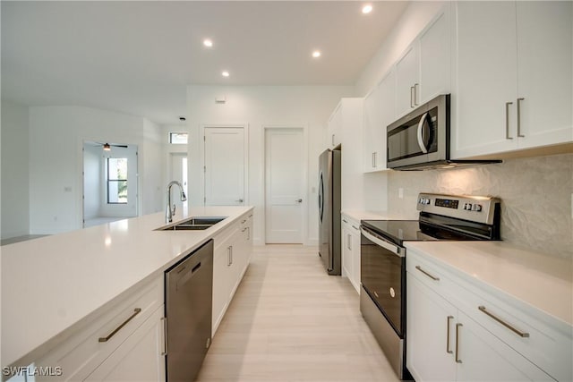 kitchen featuring sink, ceiling fan, appliances with stainless steel finishes, tasteful backsplash, and white cabinets