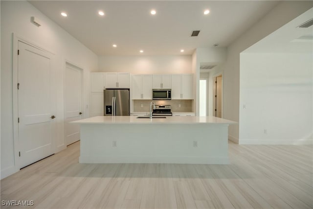 kitchen featuring appliances with stainless steel finishes, sink, white cabinets, and a spacious island