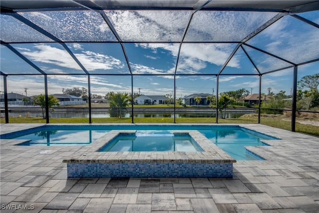 view of pool with an in ground hot tub, a water view, a patio, and glass enclosure