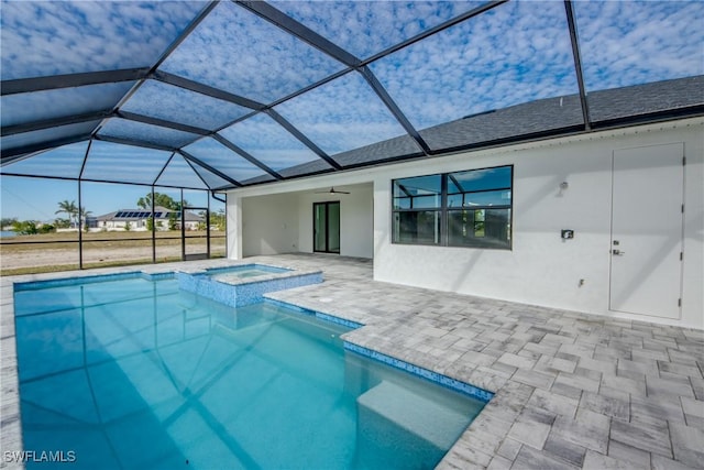 view of swimming pool featuring an in ground hot tub, ceiling fan, glass enclosure, and a patio area