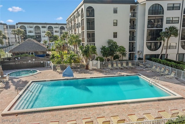 view of swimming pool with a hot tub and a patio