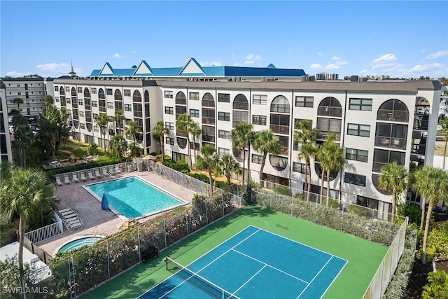 view of tennis court with a community pool