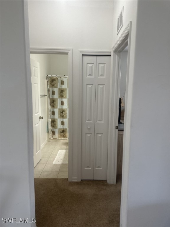 hallway with light colored carpet