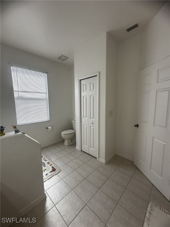 bathroom featuring toilet and tile patterned flooring