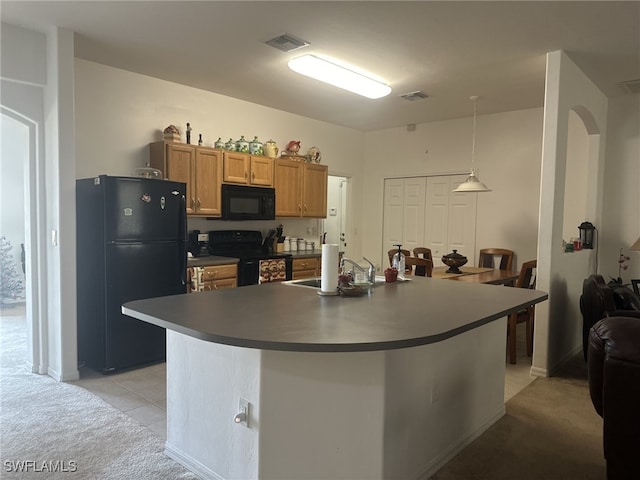 kitchen featuring sink, light tile patterned floors, pendant lighting, a kitchen island with sink, and black appliances