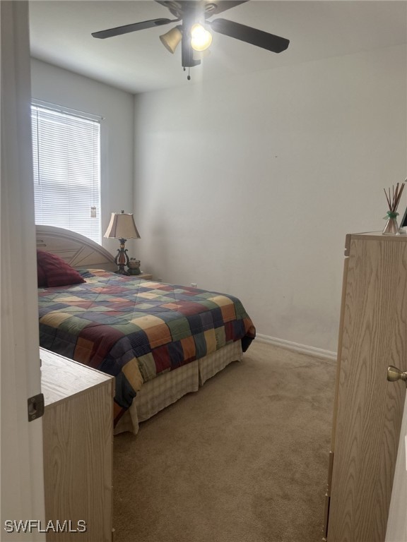 bedroom with light carpet and ceiling fan