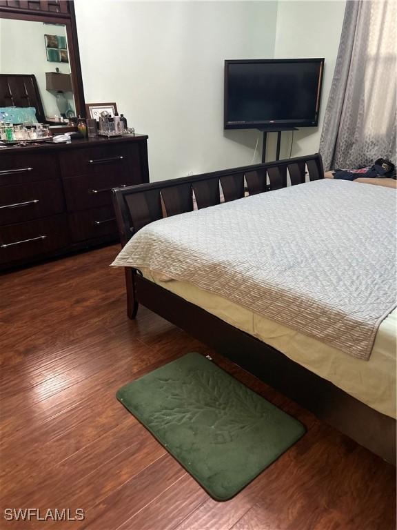 bedroom with dark hardwood / wood-style floors